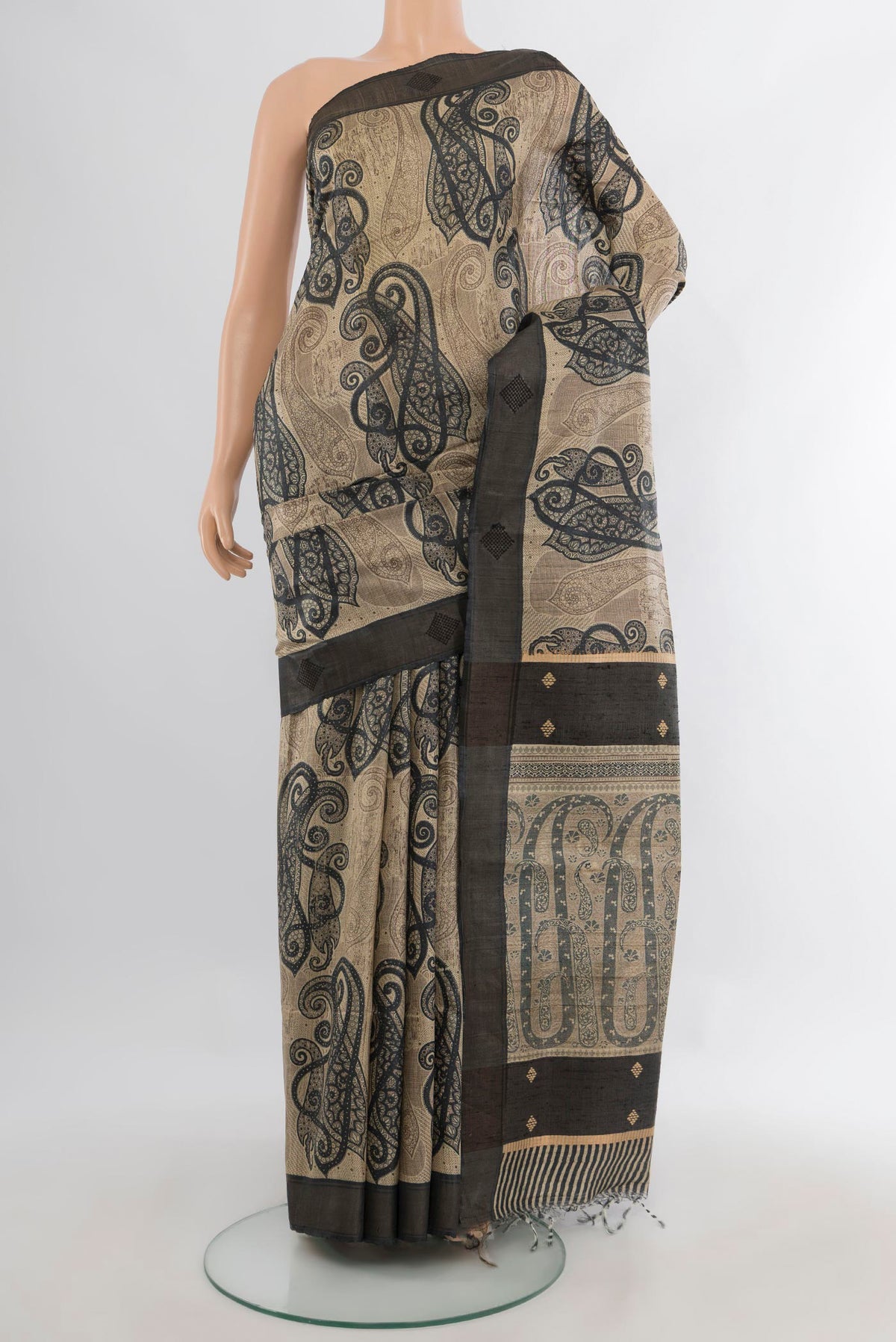 Beige Tussar Saree with Printed design on the body and Zari Border.  displayed on a mannequin