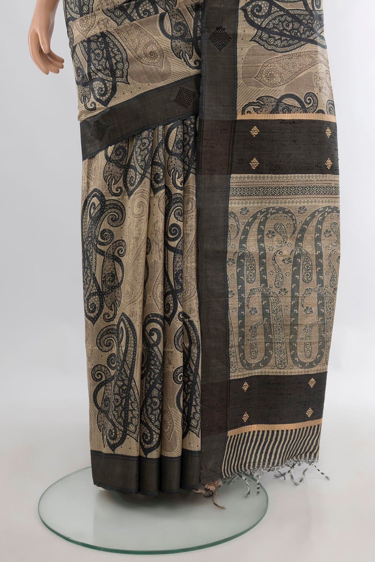 Pleats and pallu of Beige Tussar Saree with Printed design on the body and Zari Border. 