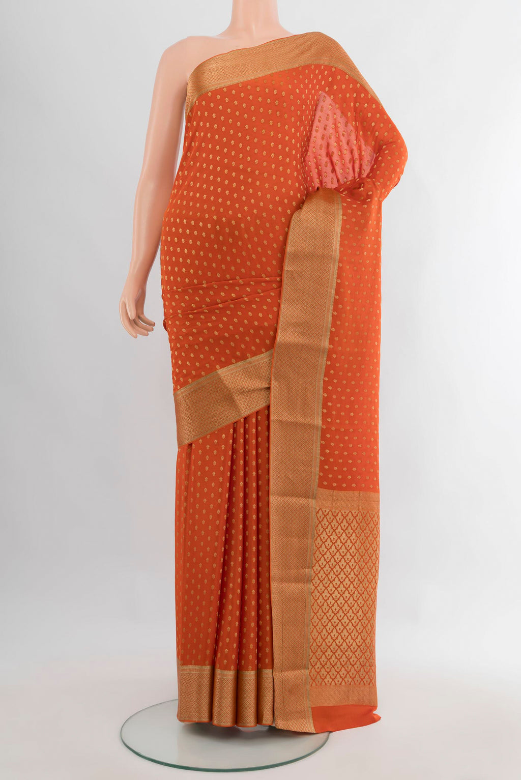 Brick Orange Mysore Crepe Saree with Zari Butta on the body and Zari Border.  displayed on a mannequin