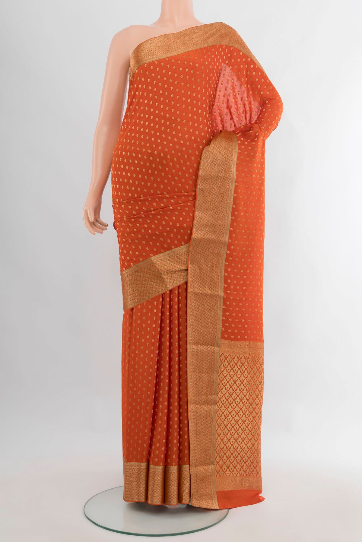 Brick Orange Mysore Crepe Saree with Zari Butta on the body and Zari Border.  displayed on a mannequin