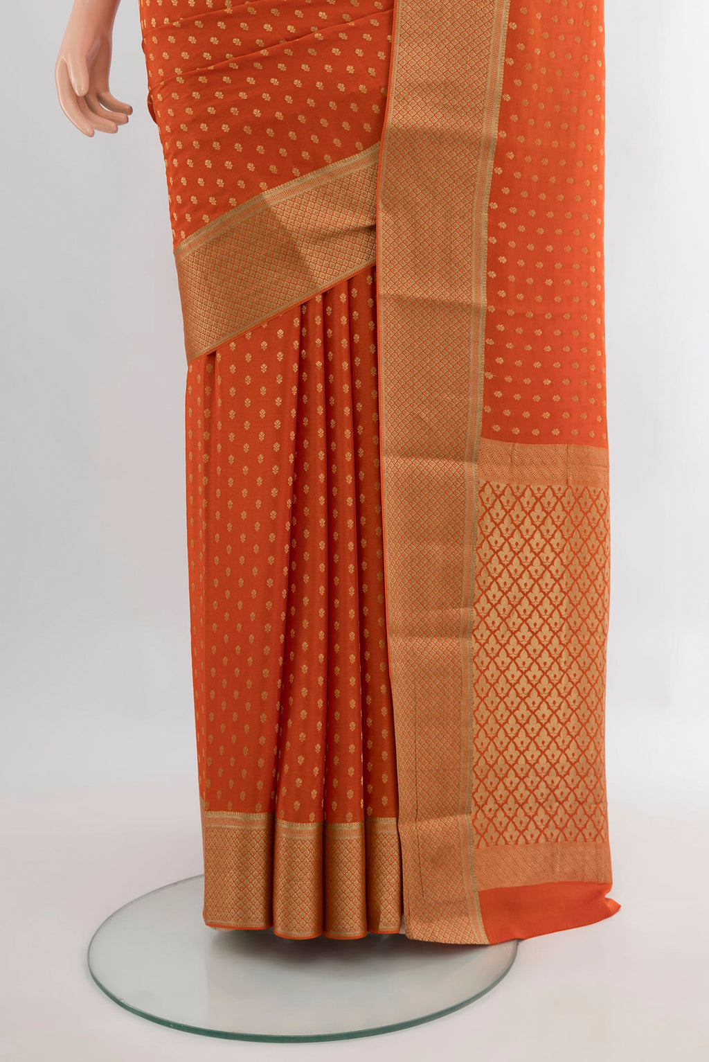 Pleats and pallu of Brick Orange Mysore Crepe Saree with Zari Butta on the body and Zari Border. 
