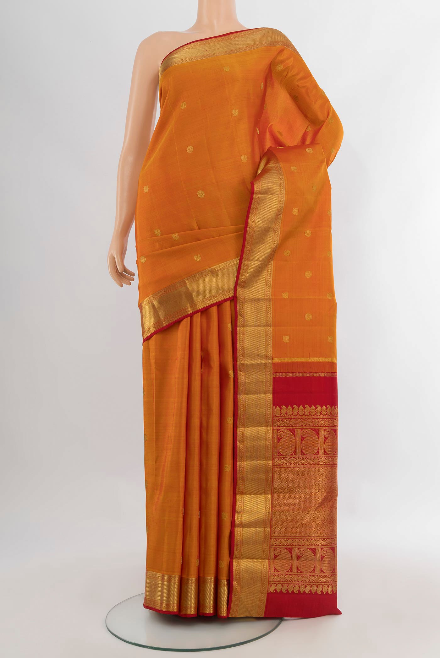 Pure Silk Pure Zari Mustard Kanjivaram Saree with Zari Butta on the body and Zari Border.  displayed on a mannequin