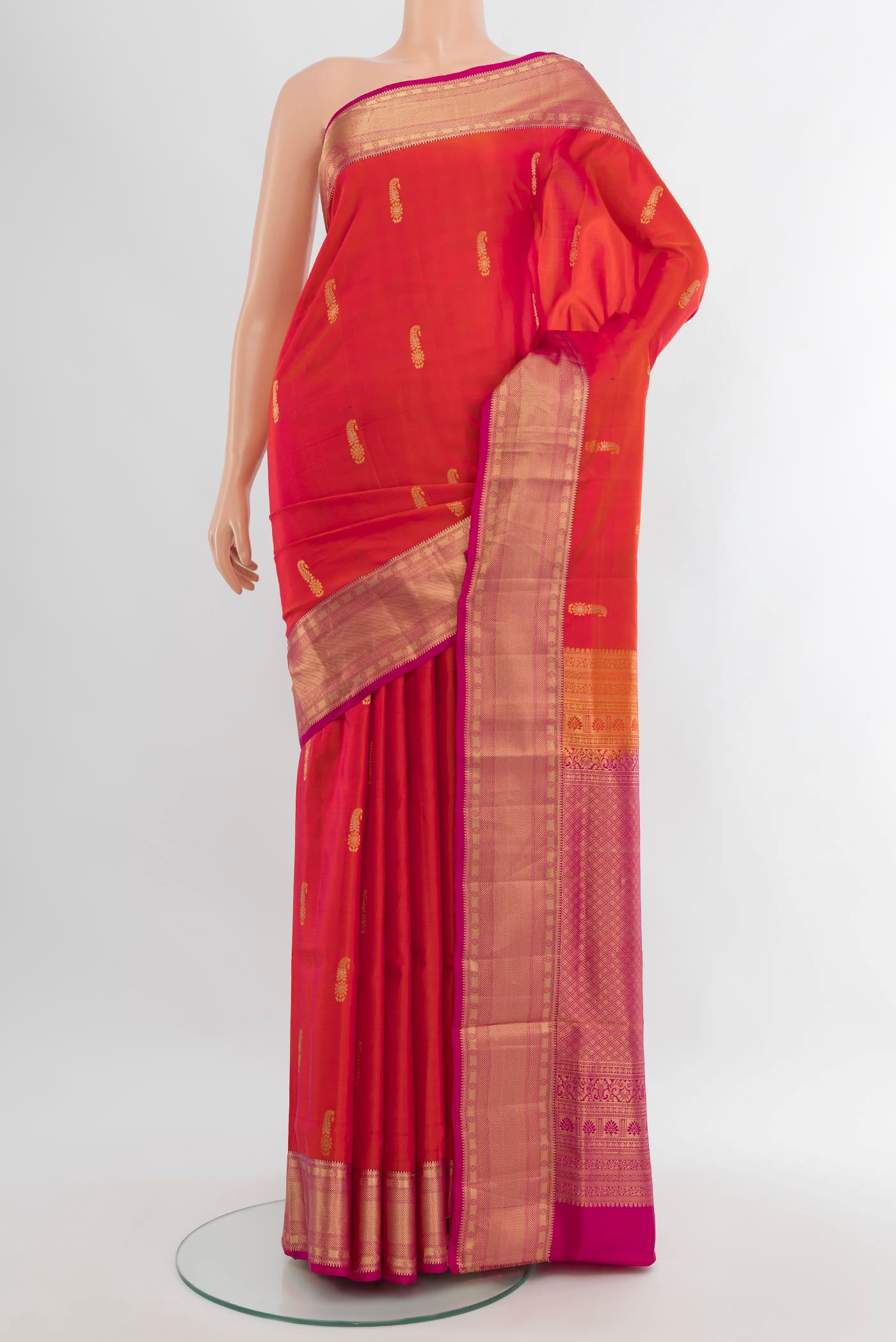 Brick Orange Soft Silk Saree with Zari Butta on the body and Zari Border.  displayed on a mannequin