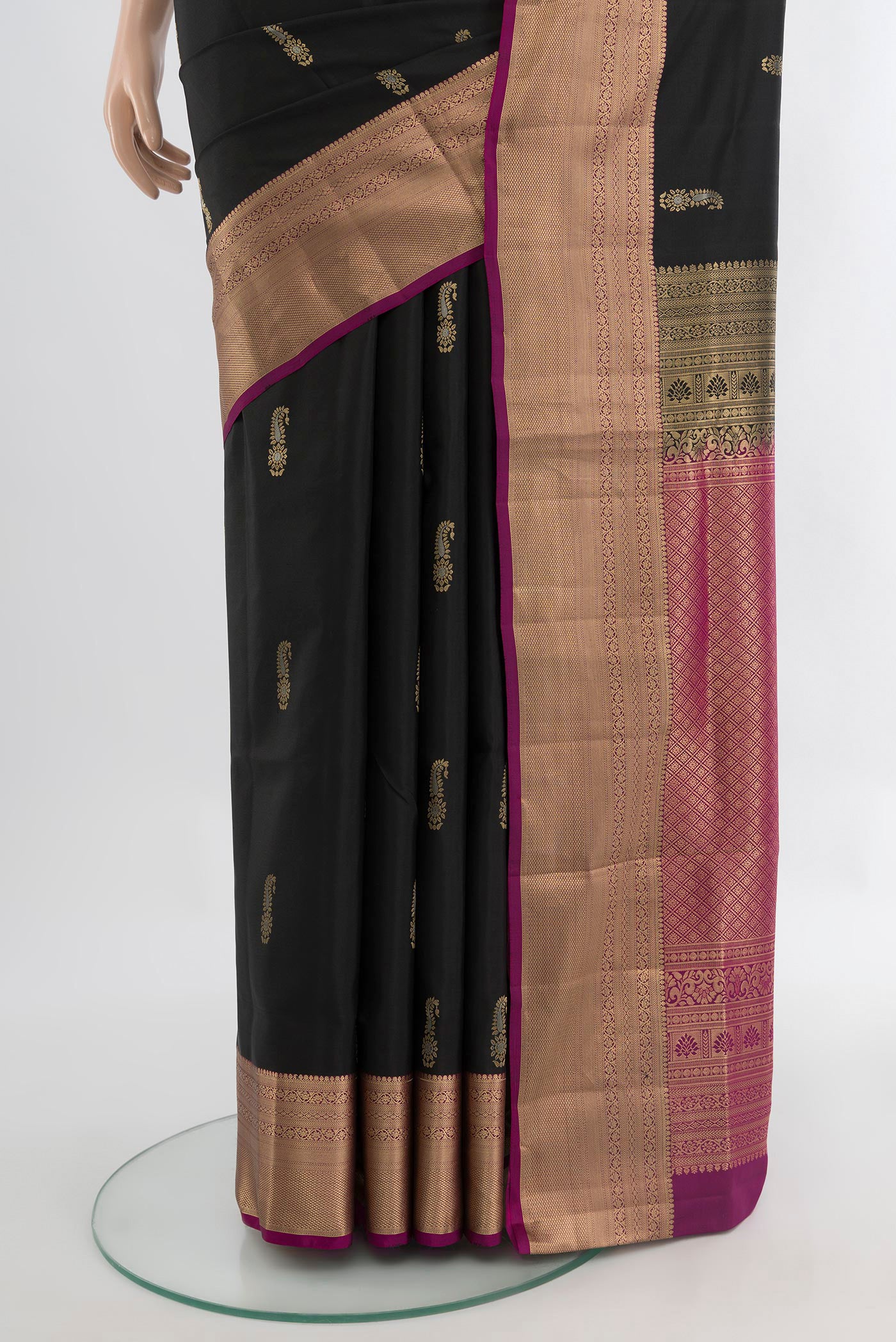 Pleats and pallu of Black Soft Silk Saree with Zari Butta on the body and Silk Border. 