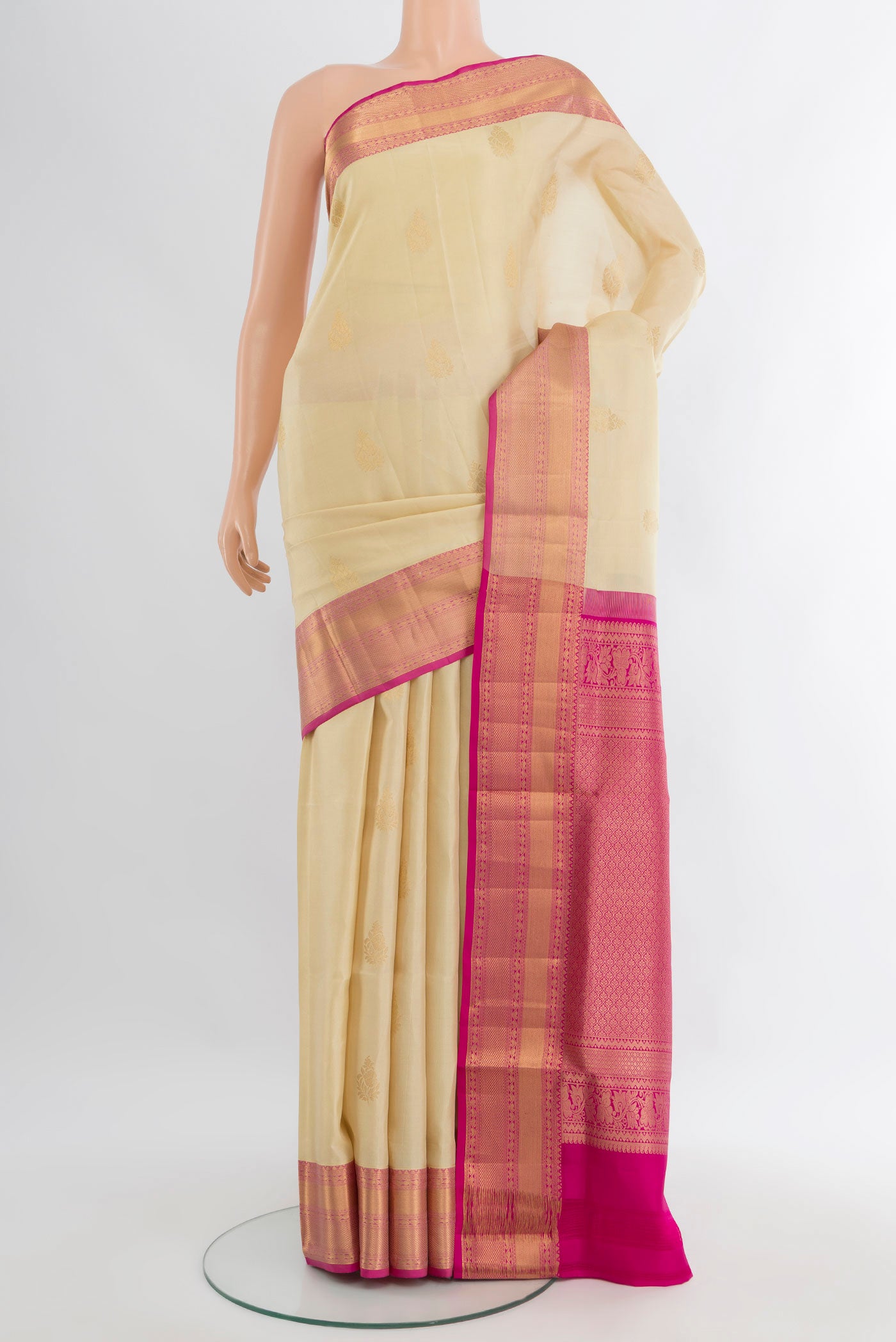 Cream Soft Silk Saree with Zari Butta on the body and Zari Border.  displayed on a mannequin