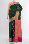 Bottle Green Soft Silk Saree with Zari Butta on the body and Zari Border.  displayed on a mannequin