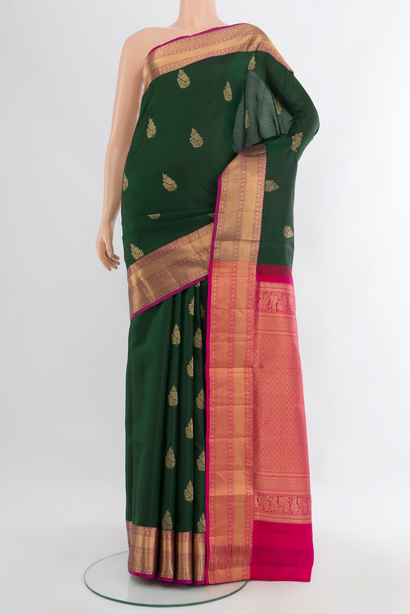 Bottle Green Soft Silk Saree with Zari Butta on the body and Zari Border.  displayed on a mannequin