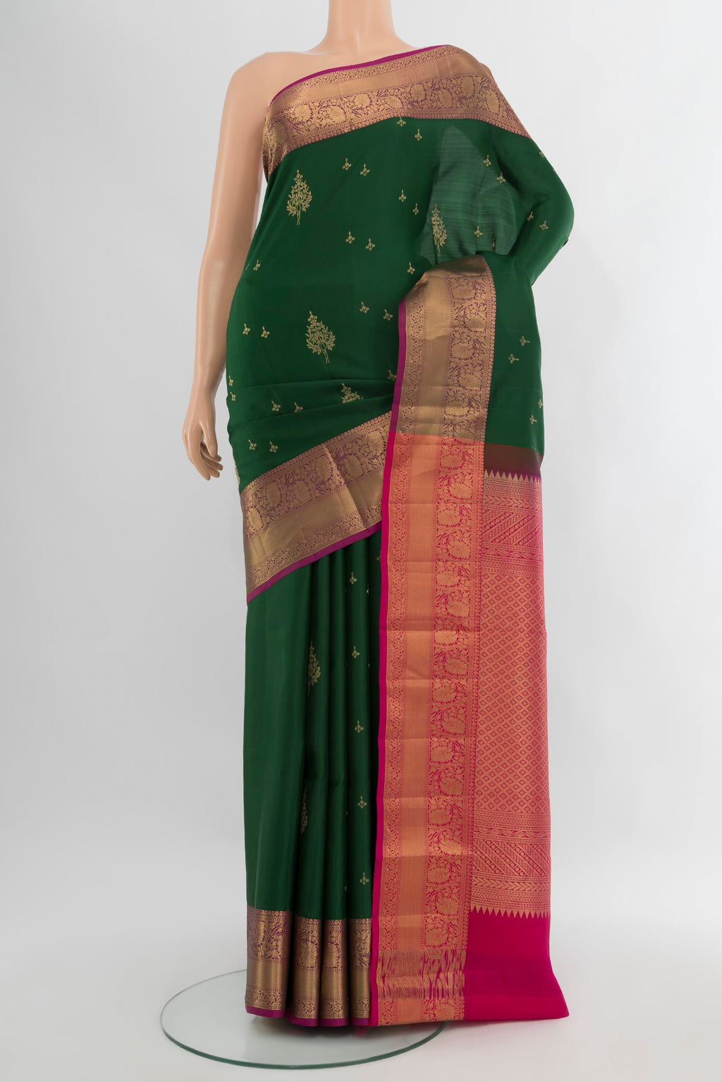 Bottle Green Soft Silk Saree with Zari Butta on the body and Zari Border.  displayed on a mannequin