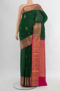Bottle Green Soft Silk Saree with Zari Butta on the body and Zari Border.  displayed on a mannequin