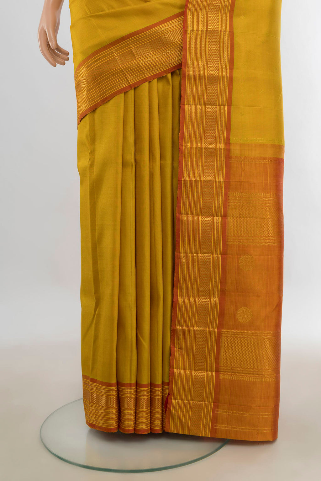 Pleats and pallu of Pure Silk Mustard Kanchipuram Saree with Zari Butta on the body and Silk Border. 
