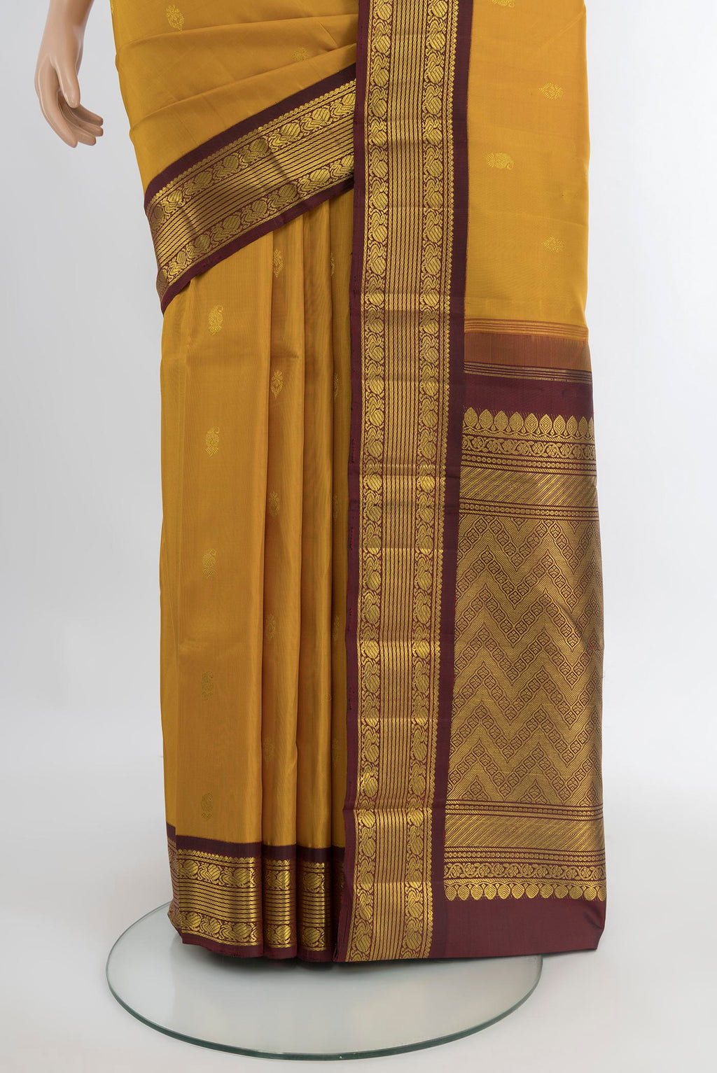 Pleats and pallu of Mustard Kanchipuram Silk Saree with Zari Butta on the body and Zari Border. 