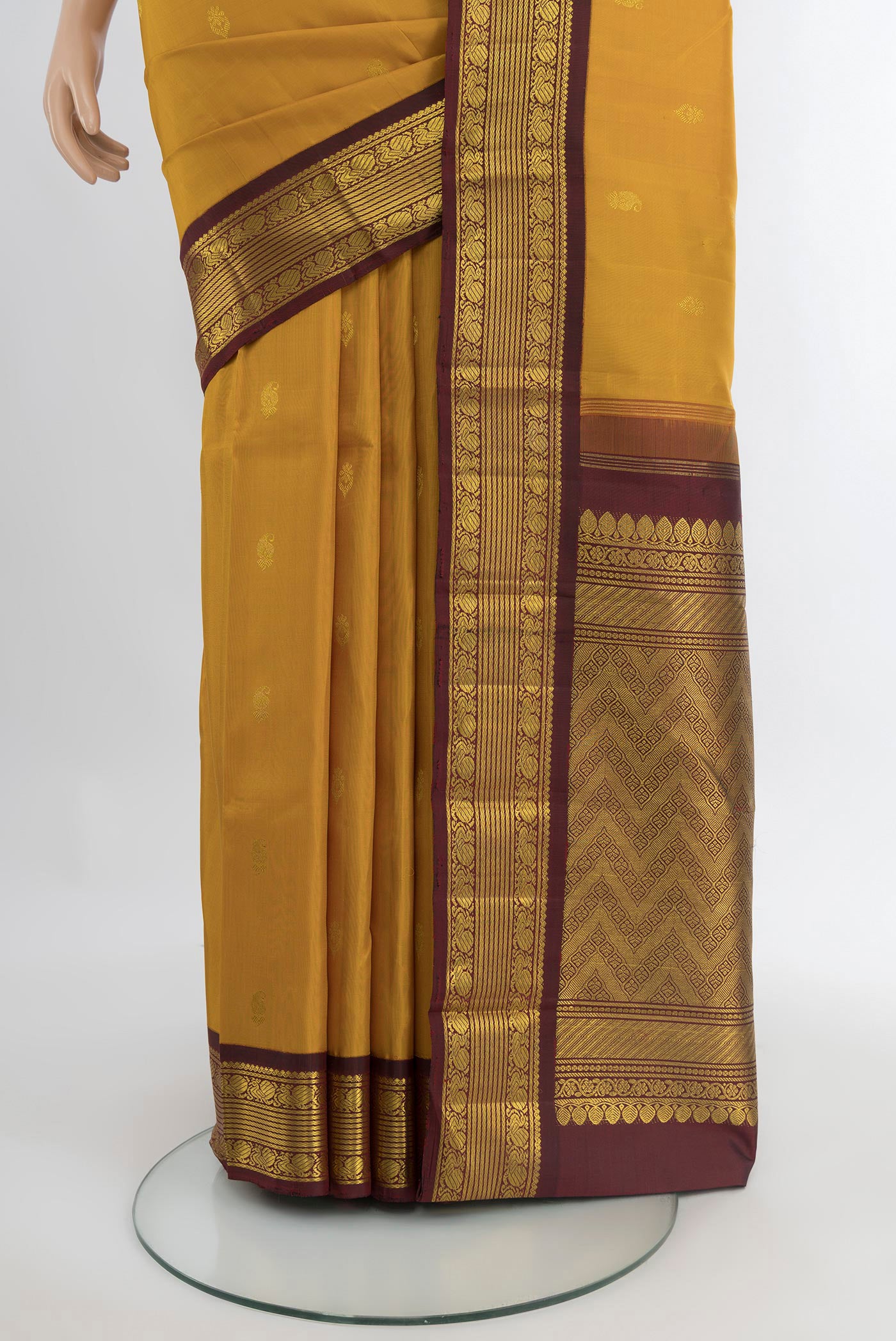 Pleats and pallu of Mustard Kanchipuram Silk Saree with Zari Butta on the body and Zari Border. 