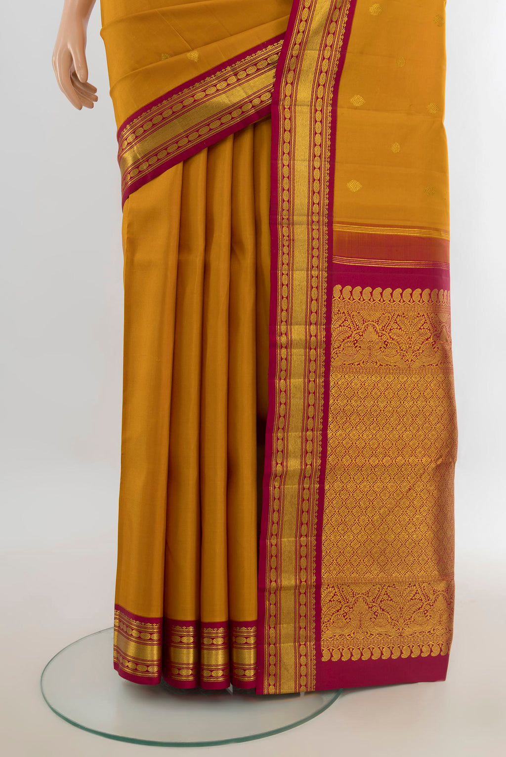 Pleats and pallu of Pure Silk Pure Zari Mustard Kanchipuram Saree with Zari Butta on the body and Silk Border. 