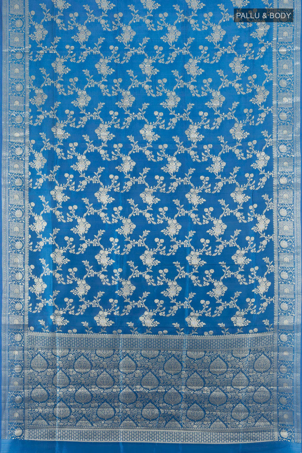 Flat view of Pure Silk Light Blue Banarasi Raw Saree with Zari Butta on the body and Zari Border. 
