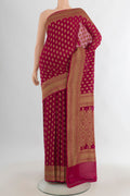 Maroon Banarasi Georgette Saree with Zari Butta on the body and Zari Border.  displayed on a mannequin