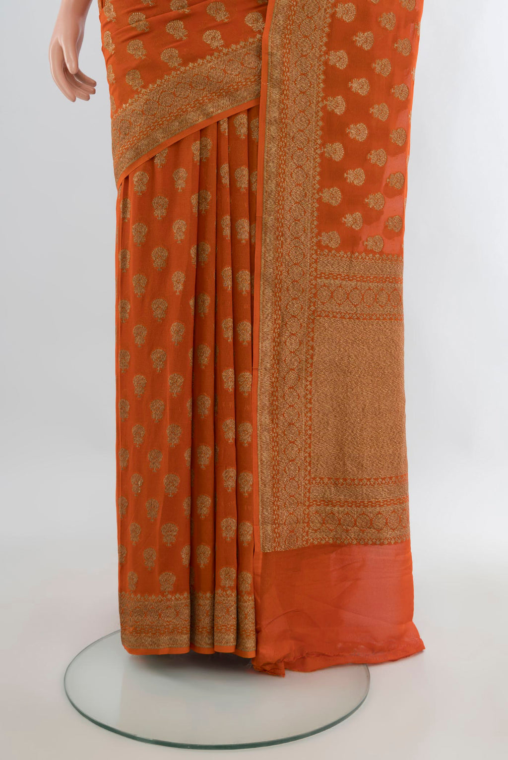 Pleats and pallu of Orange Banarasi Georgette Saree with Zari Butta on the body and Zari Border. 