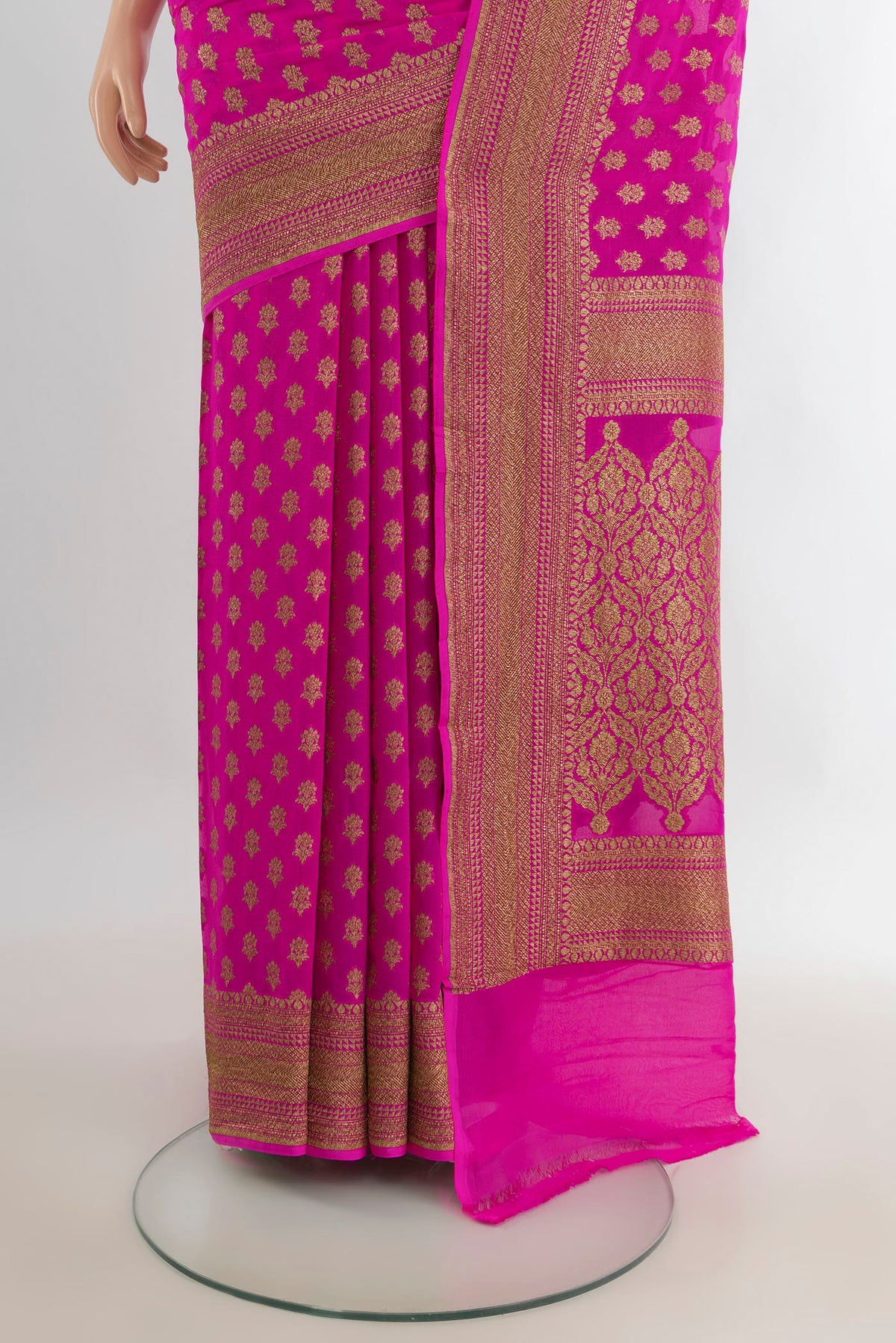 Pleats and pallu of Rani Pink Banarasi Georgette Saree with Zari Butta on the body and Zari Border. 