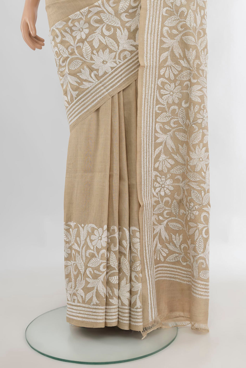 Pleats and pallu of Beige Tussar Saree with Kantha Work on the body and Embroidery Border. 