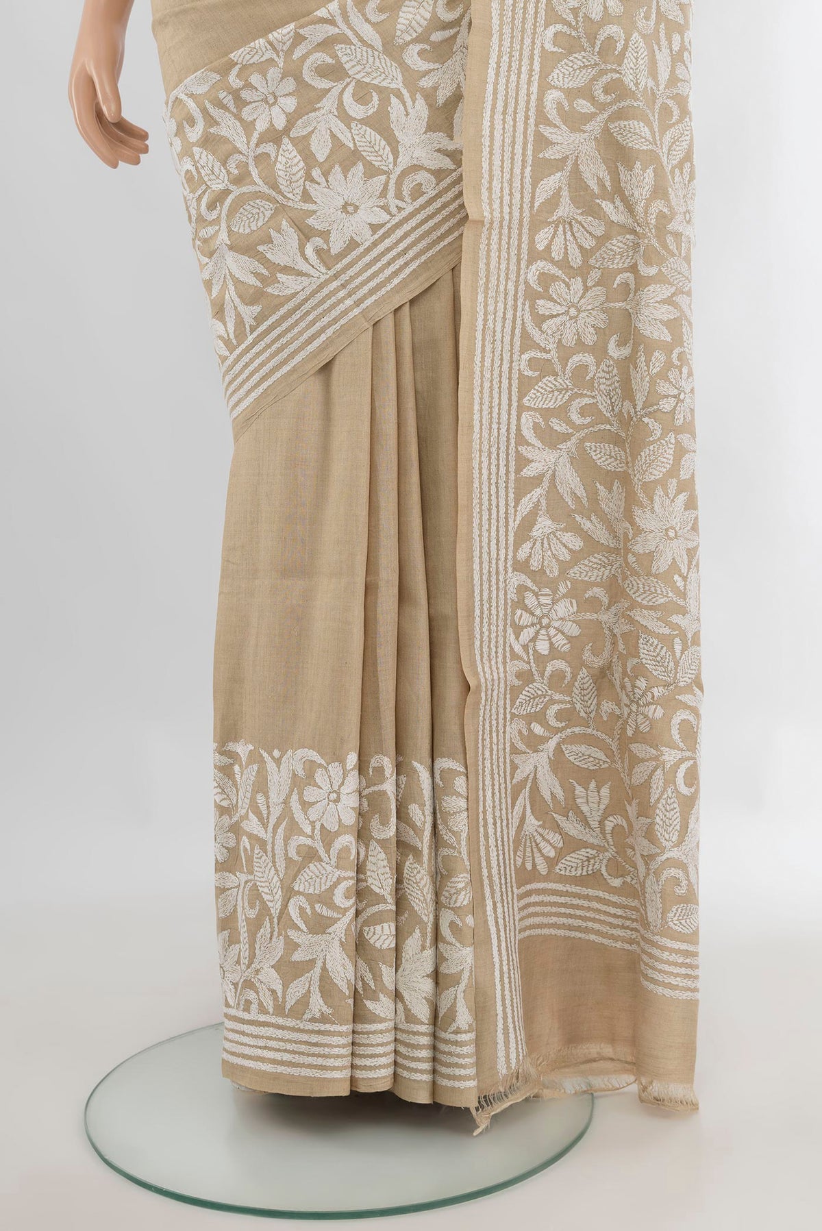 Pleats and pallu of Beige Tussar Saree with Kantha Work on the body and Embroidery Border. 