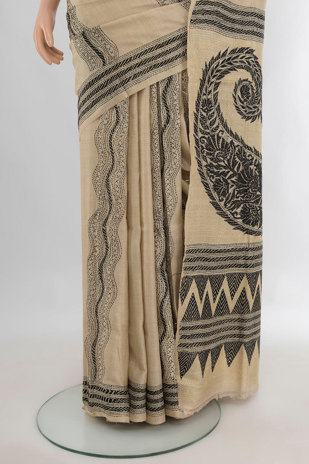 Pleats and pallu of Beige Tussar Saree with Kantha Work on the body and Embroidery Border. 