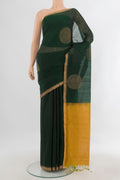 Bottle Green Silk Cotton Saree with Zari Butta on the body and Zari Border.  displayed on a mannequin