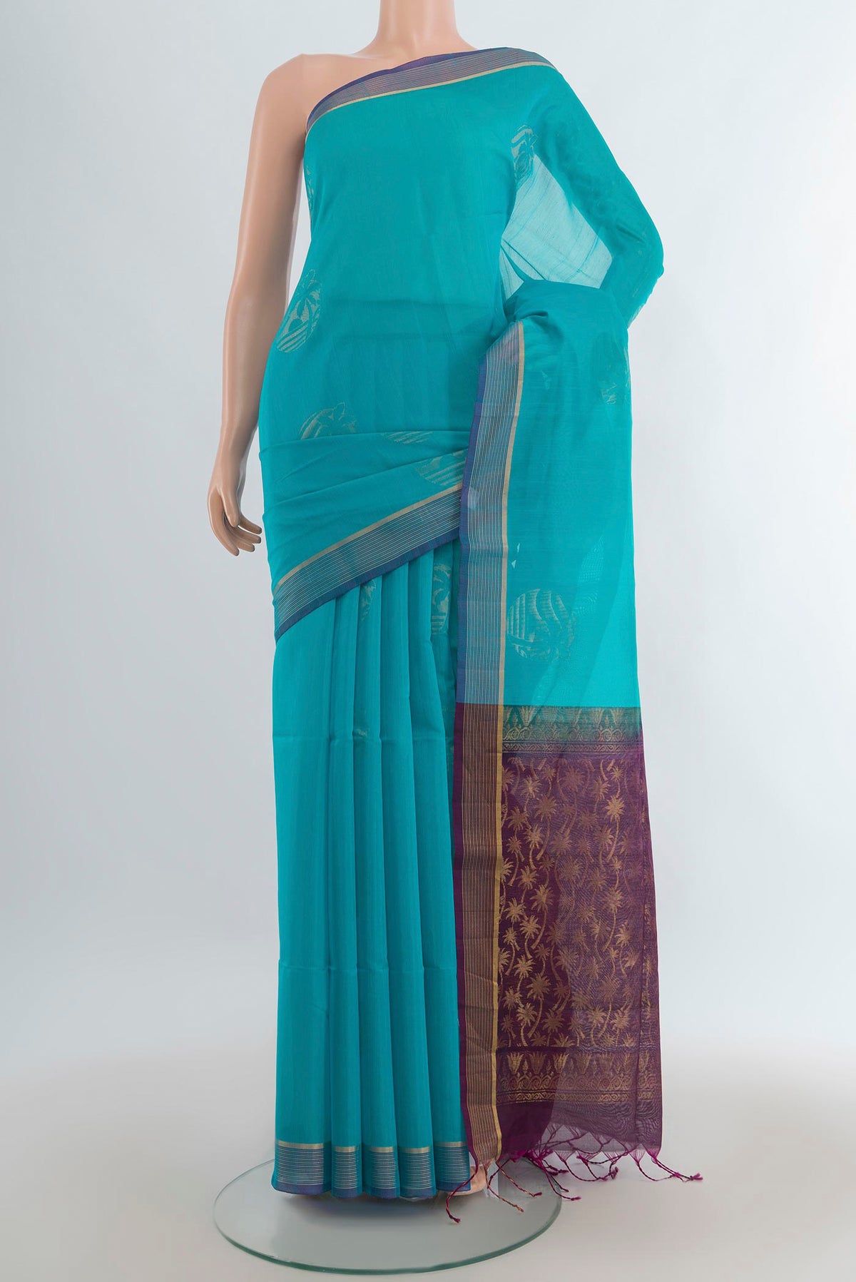 Light Blue Silk Cotton Saree with Zari Butta on the body and Zari Border.  displayed on a mannequin