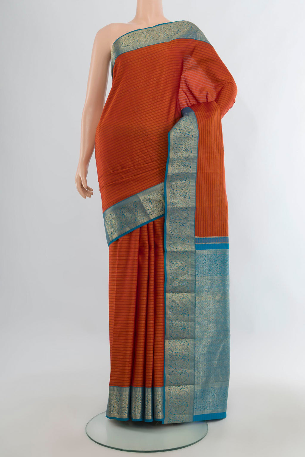 Pure Silk Rust Kanjivaram Saree with Stripes on the body and Zari Border.  displayed on a mannequin