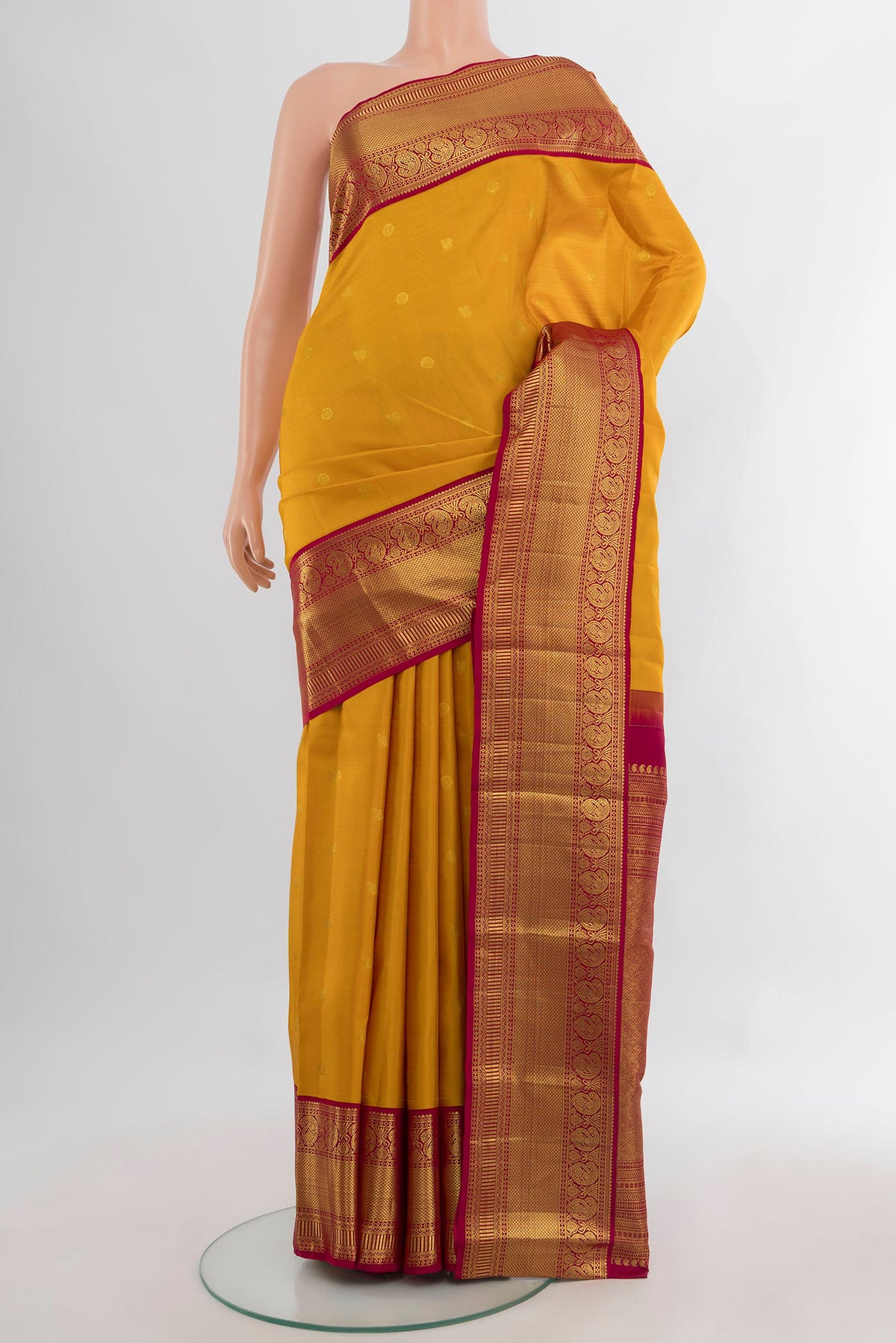Pure Silk Mustard Kanjivaram Saree with Zari Butta on the body and Zari Border.  displayed on a mannequin