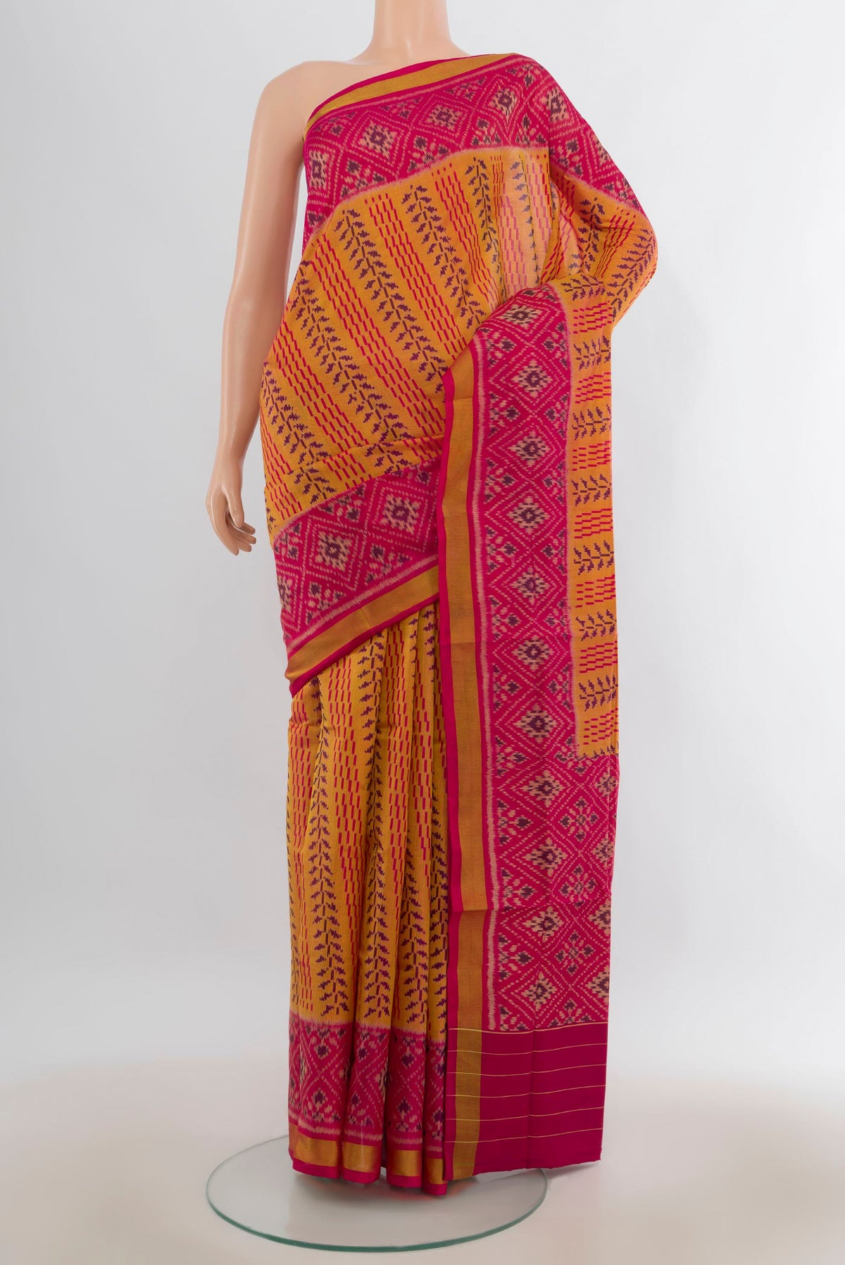 Pure Silk Mustard Rajkot Patola Saree with Pure Ikat on the body and Ikat Border.  displayed on a mannequin