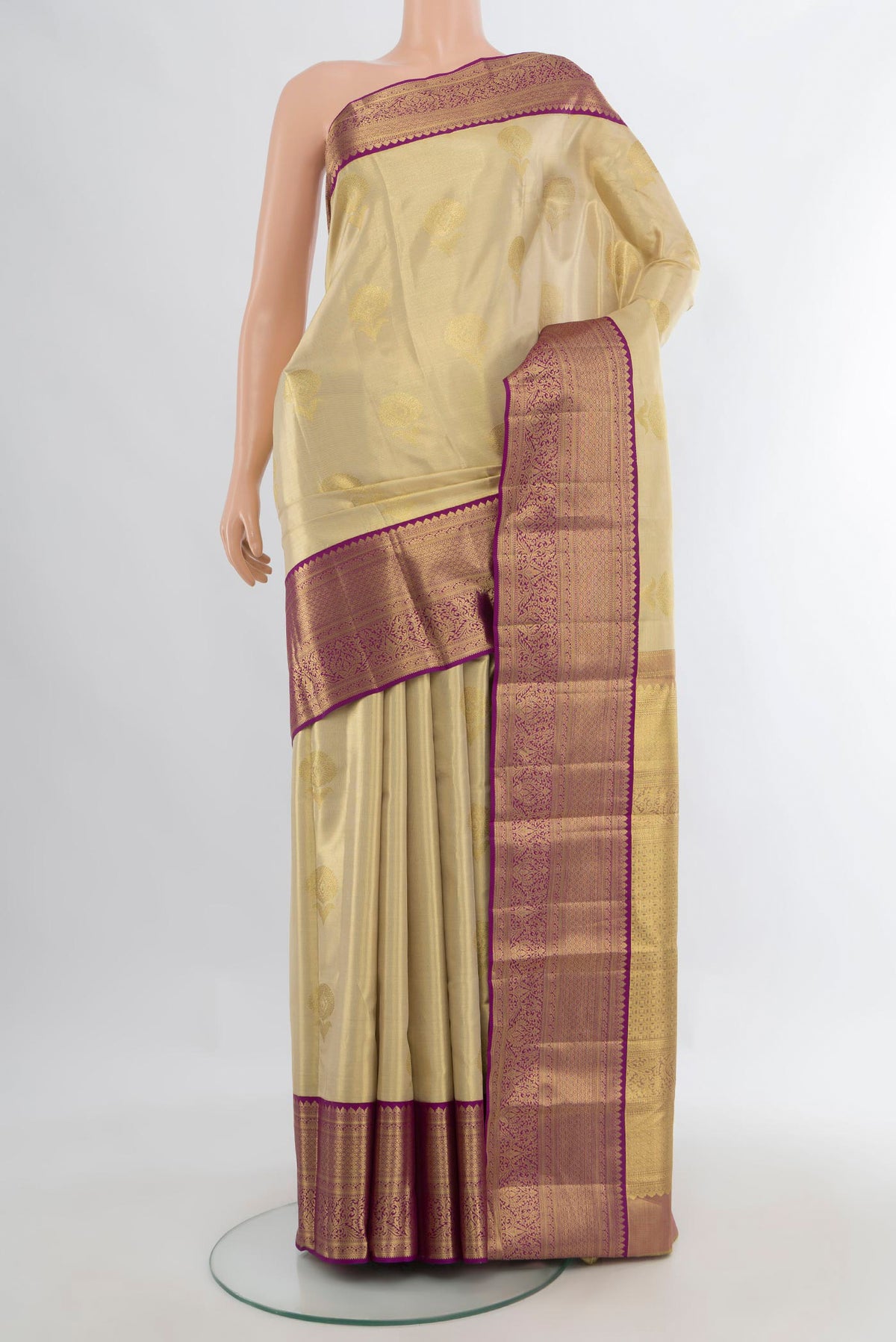 Golden Kanchipuram Tissue Saree with Zari Butta on the body and Zari Border.  displayed on a mannequin