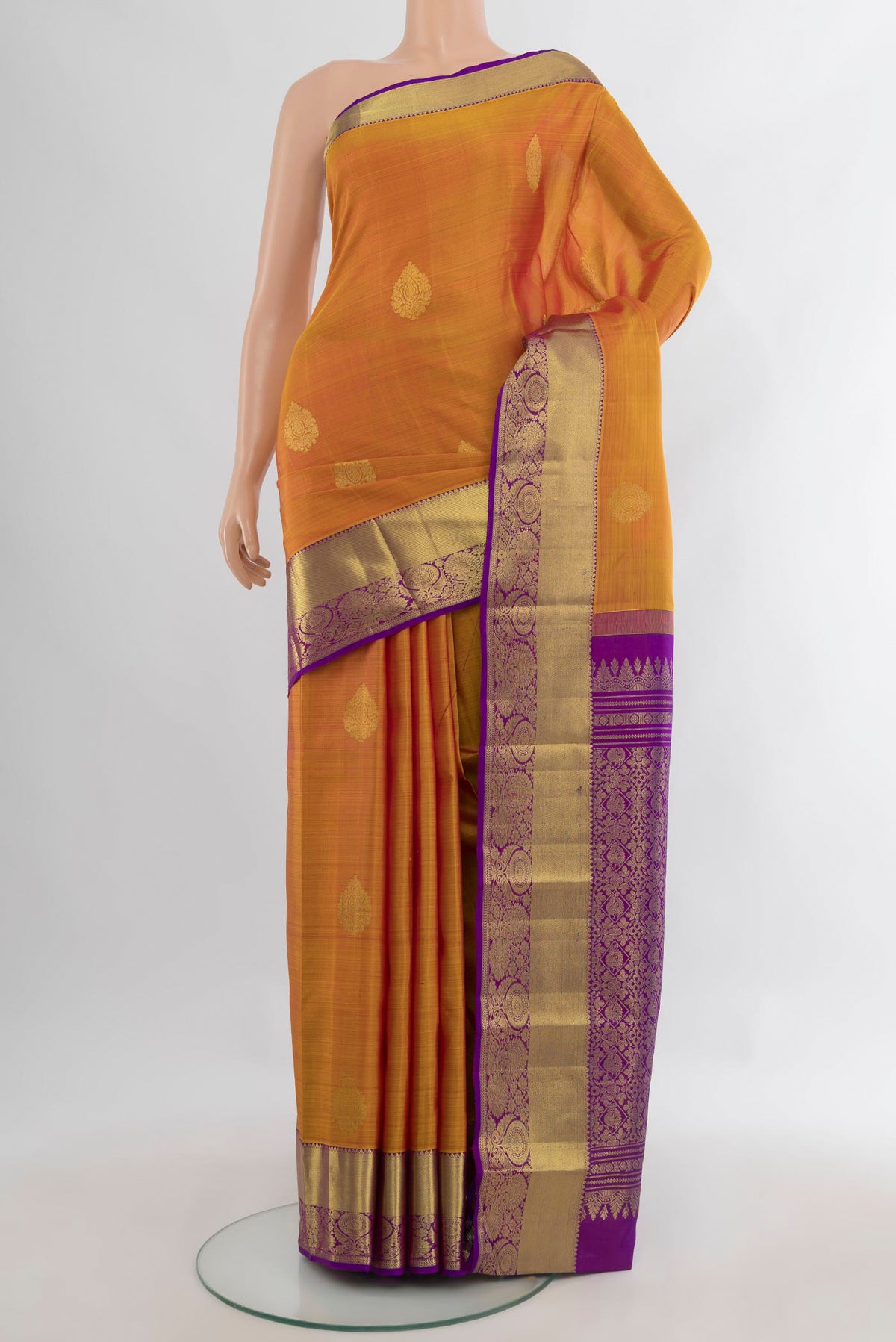Pure Silk Mustard Kanchipuram Saree with Zari Butta on the body and Zari Border.  displayed on a mannequin