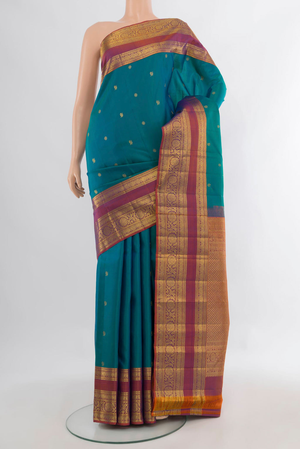 Pure Silk Peacock Blue Kanchipuram Saree with Zari Butta on the body and Zari Border.  displayed on a mannequin