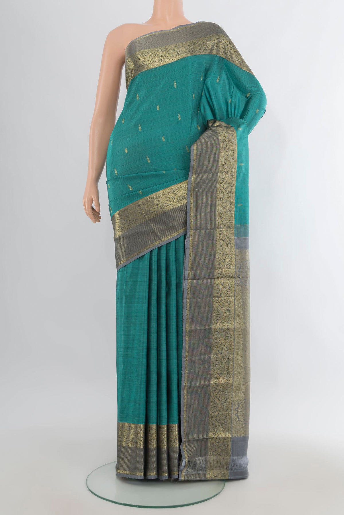 Pure Silk Teal Kanchipuram Saree with Zari Butta on the body and Zari Border.  displayed on a mannequin