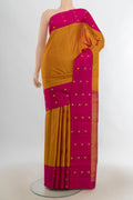 Pure Silk Rust Kanjivaram Saree with Zari Butta on the body and Silk Border.  displayed on a mannequin