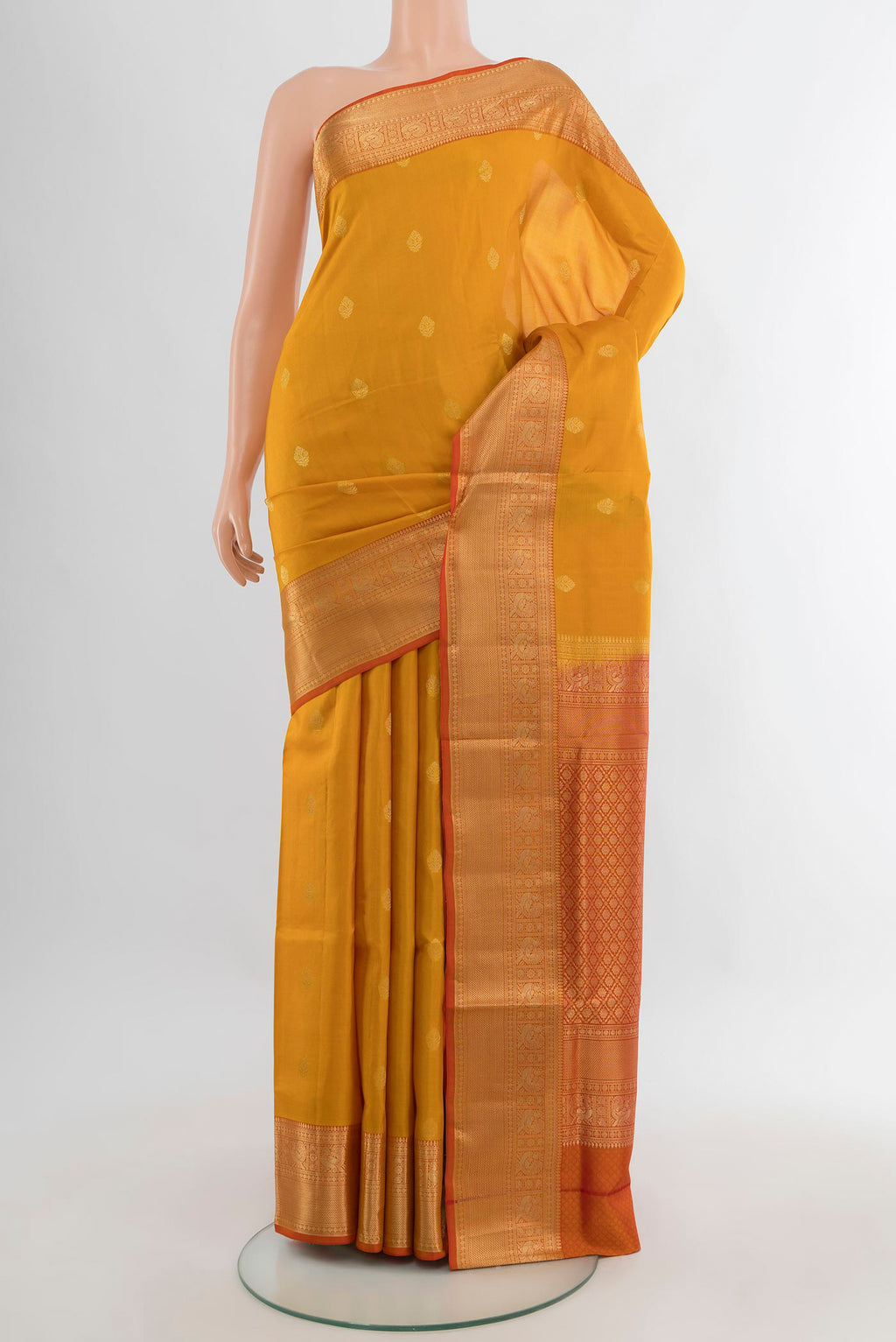 Pure Silk Mustard Soft Saree with Zari Butta on the body and Zari Border.  displayed on a mannequin
