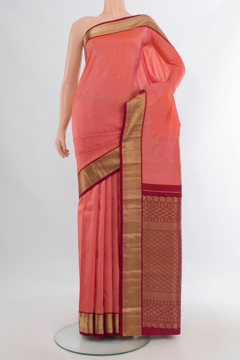 Pure Silk Coral Kanchipuram Saree with Zari Butta on the body and Zari Border.  displayed on a mannequin