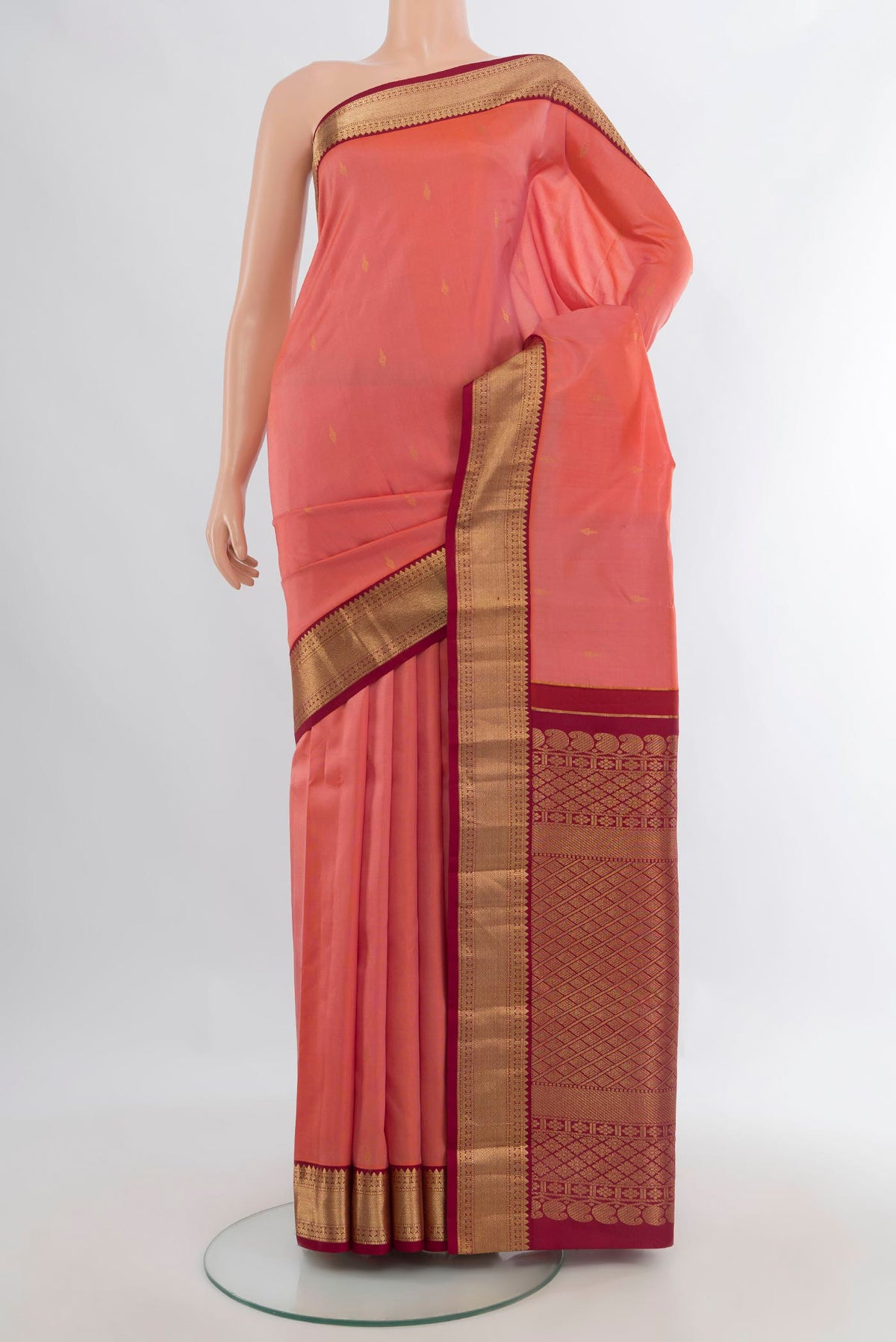 Pure Silk Coral Kanchipuram Saree with Zari Butta on the body and Zari Border.  displayed on a mannequin