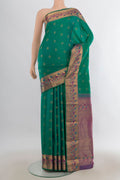 Pure Silk Green Kanjivaram Saree with Zari Butta on the body and Zari Border.  displayed on a mannequin