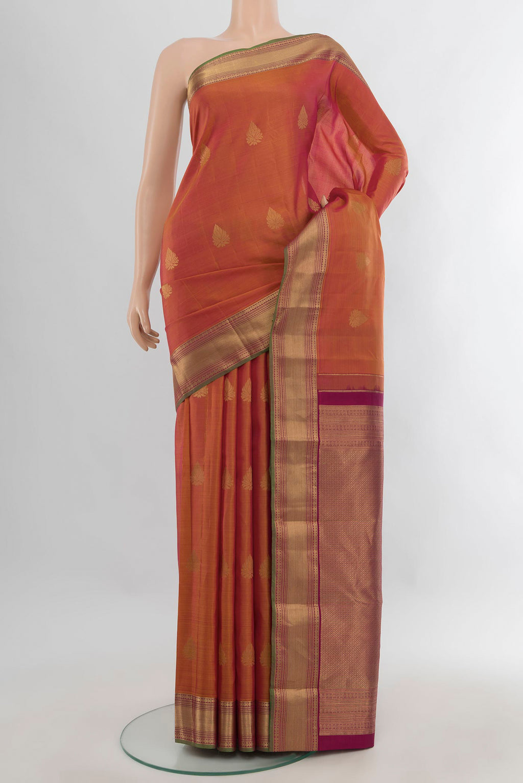 Pure Silk Rust Kanchipuram Saree with Zari Butta on the body and Zari Border.  displayed on a mannequin