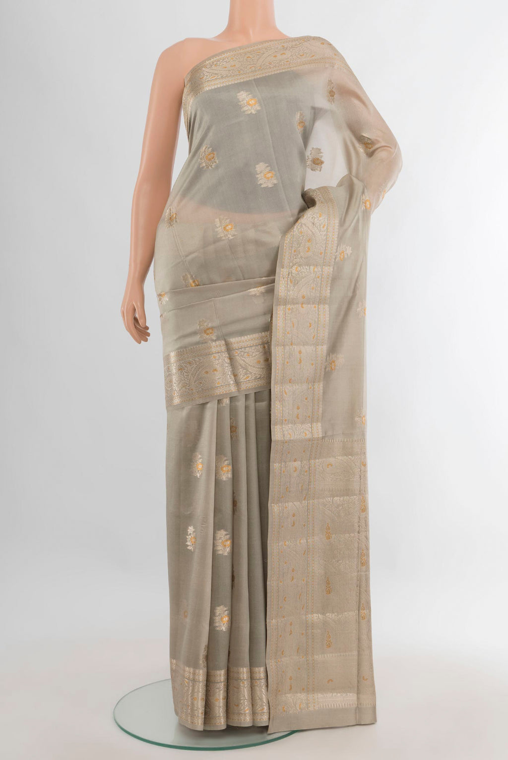 Pure Silk Beige Banarasi Raw Saree with Zari Butta on the body and Zari Border.  displayed on a mannequin