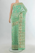 Pure Silk Light Green Banarasi Raw Saree with Zari Butta on the body and Zari Border.  displayed on a mannequin