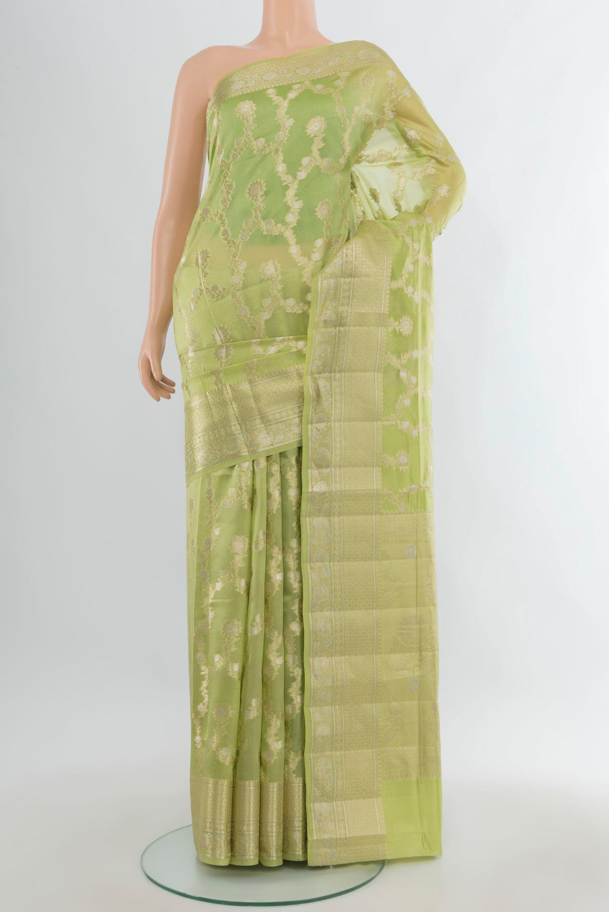 Pure Silk Pista Green Banarasi Raw Saree with Zari Butta on the body and Zari Border.  displayed on a mannequin