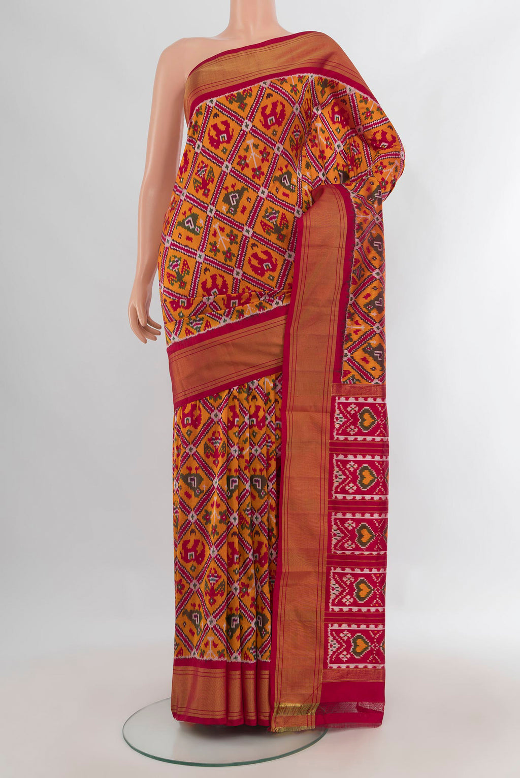 Pure Silk Orange Pochampally Saree with Pure Ikat on the body and Zari Border.  displayed on a mannequin