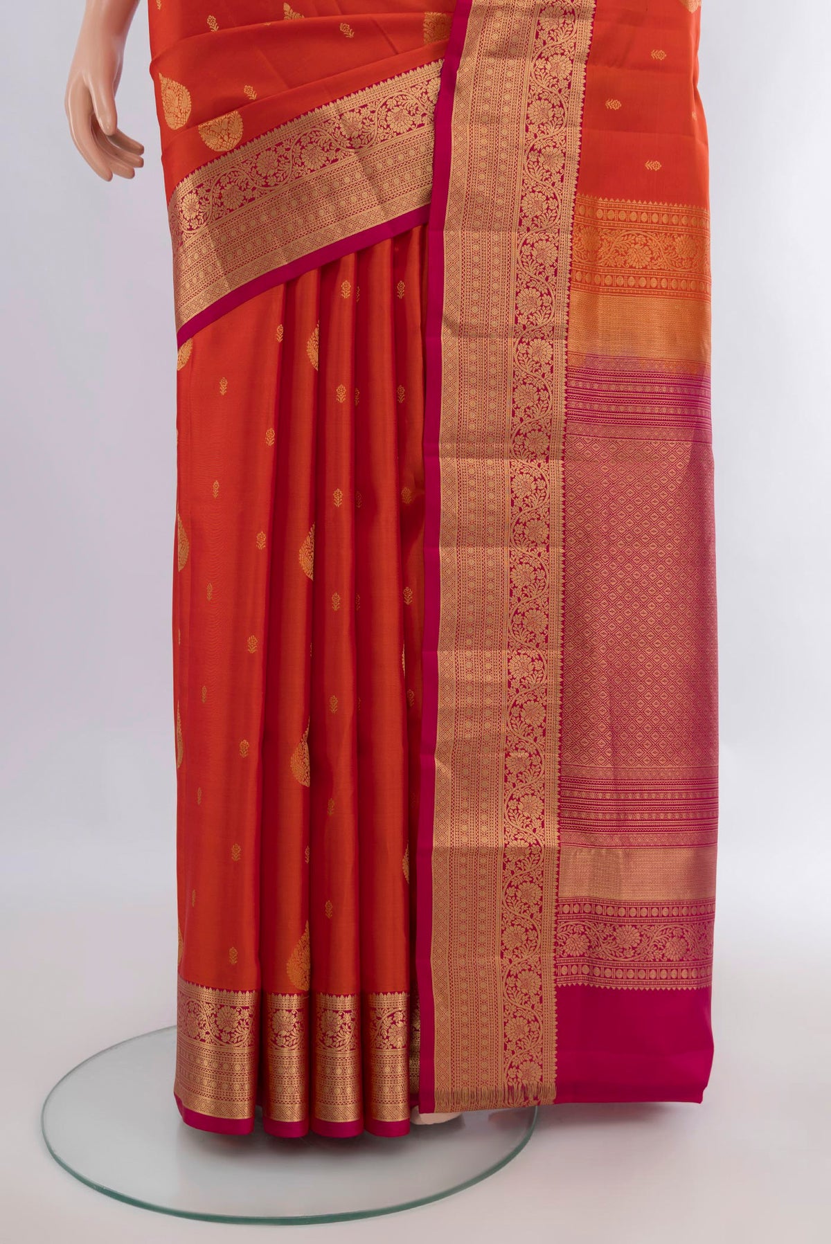 Pleats and pallu of Pure Silk Brick Orange Soft Saree with Zari Butta on the body and Zari Border. 