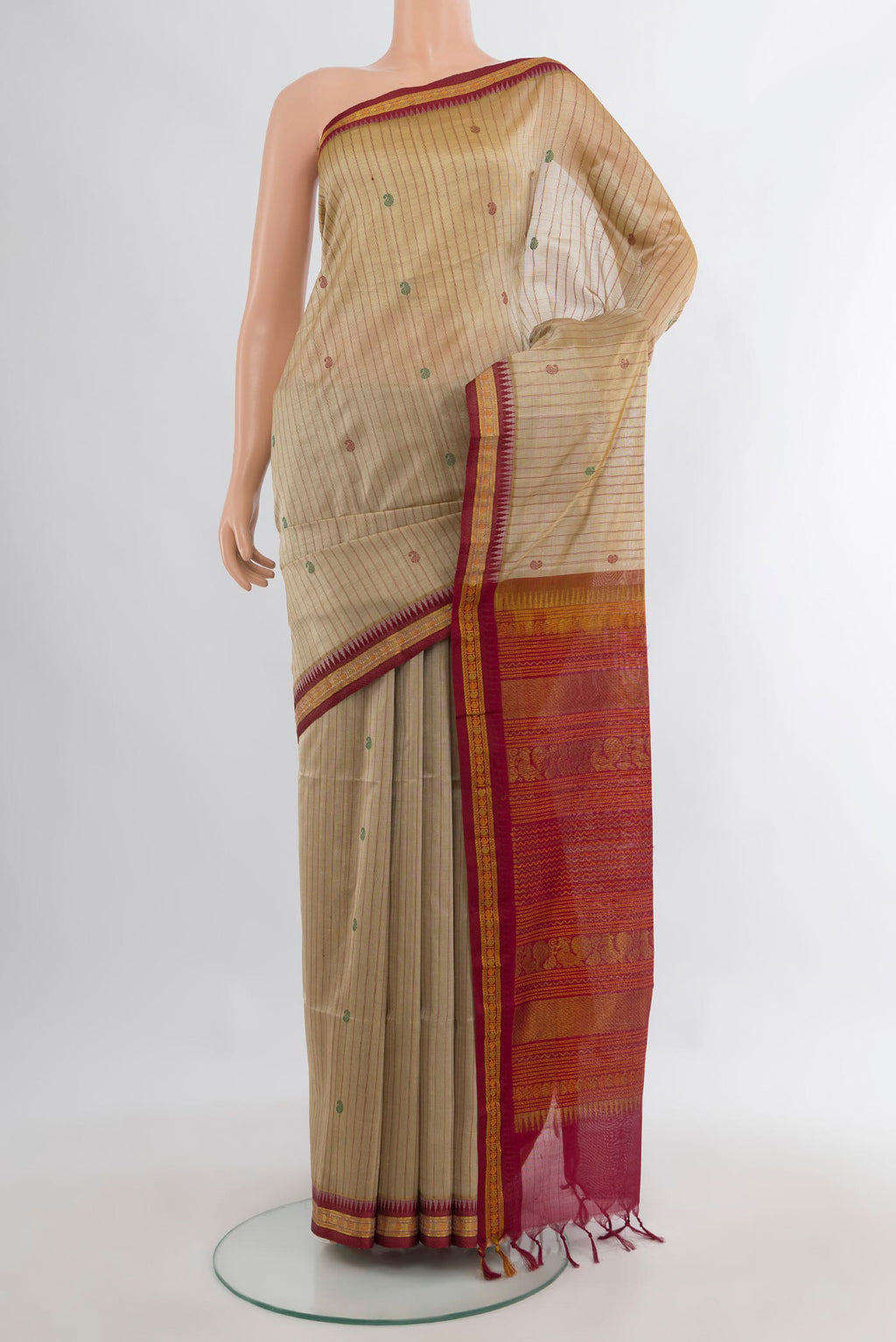 Beige Silk Cotton Saree with Stripes on the body and Zari Border.  displayed on a mannequin