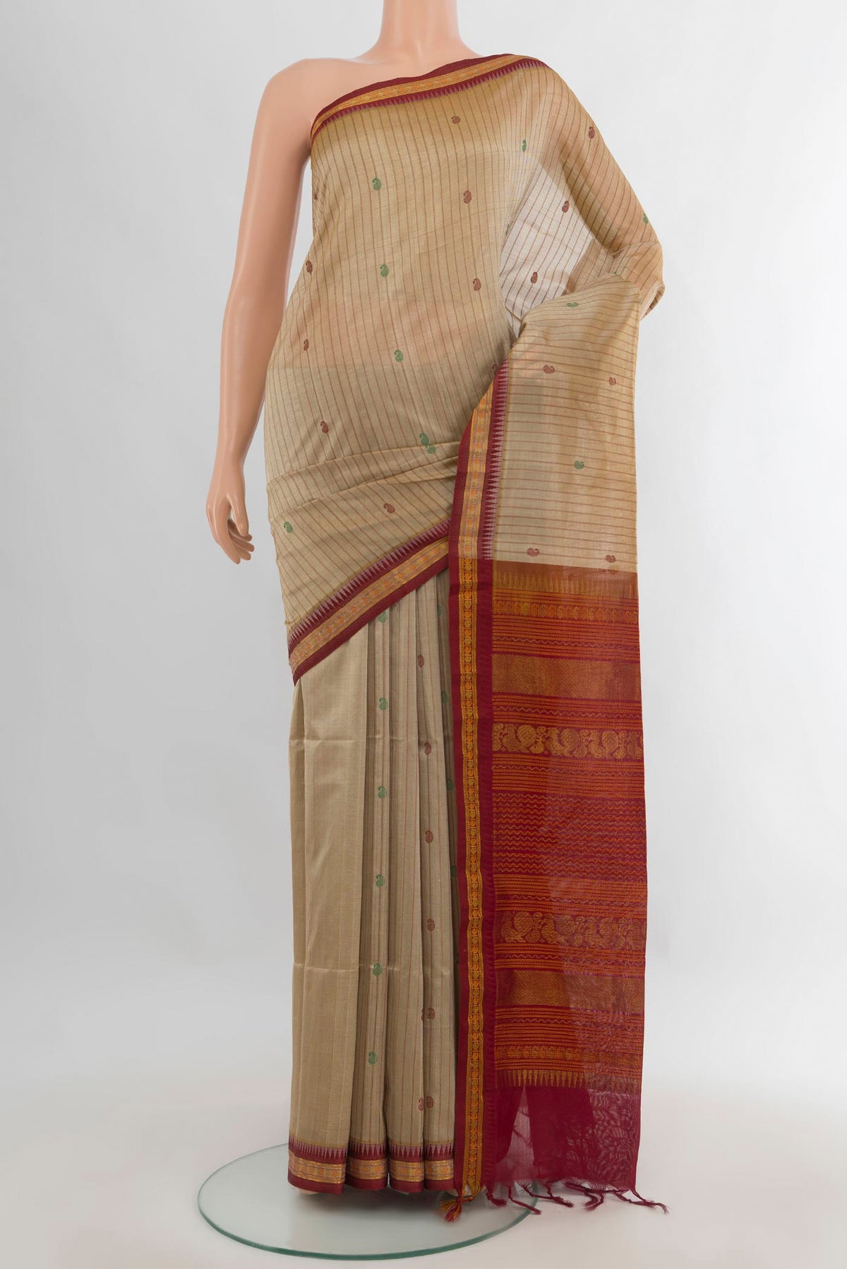 Beige Silk Cotton Saree with Stripes on the body and Zari Border.  displayed on a mannequin