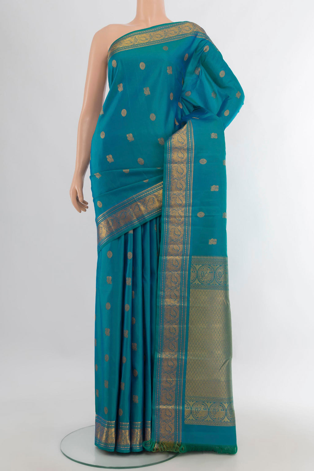 Pure Silk Peacock Blue Kanchipuram Saree with Zari Butta on the body and Zari Border.  displayed on a mannequin