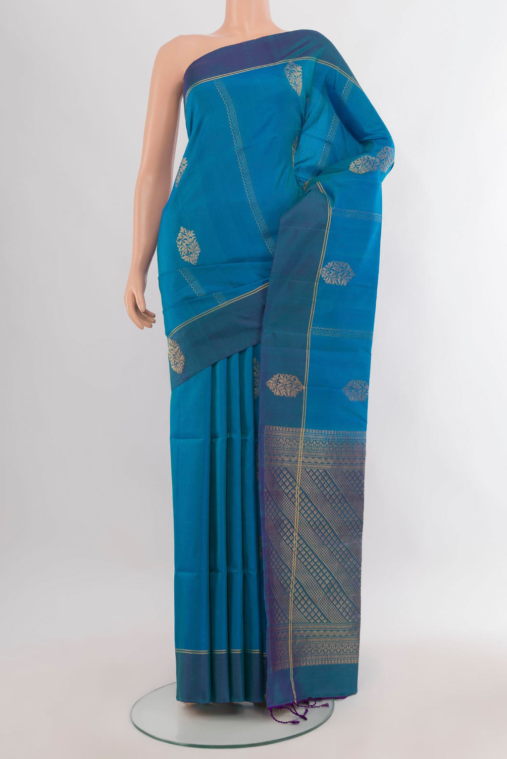 Pure Silk Peacock Blue Soft Saree with Zari Butta on the body and Plain Border.  displayed on a mannequin