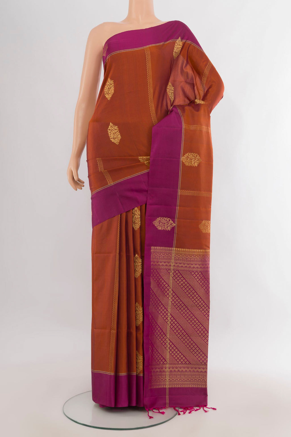 Pure Silk Rust Soft Saree with Zari Butta on the body and Plain Border.  displayed on a mannequin