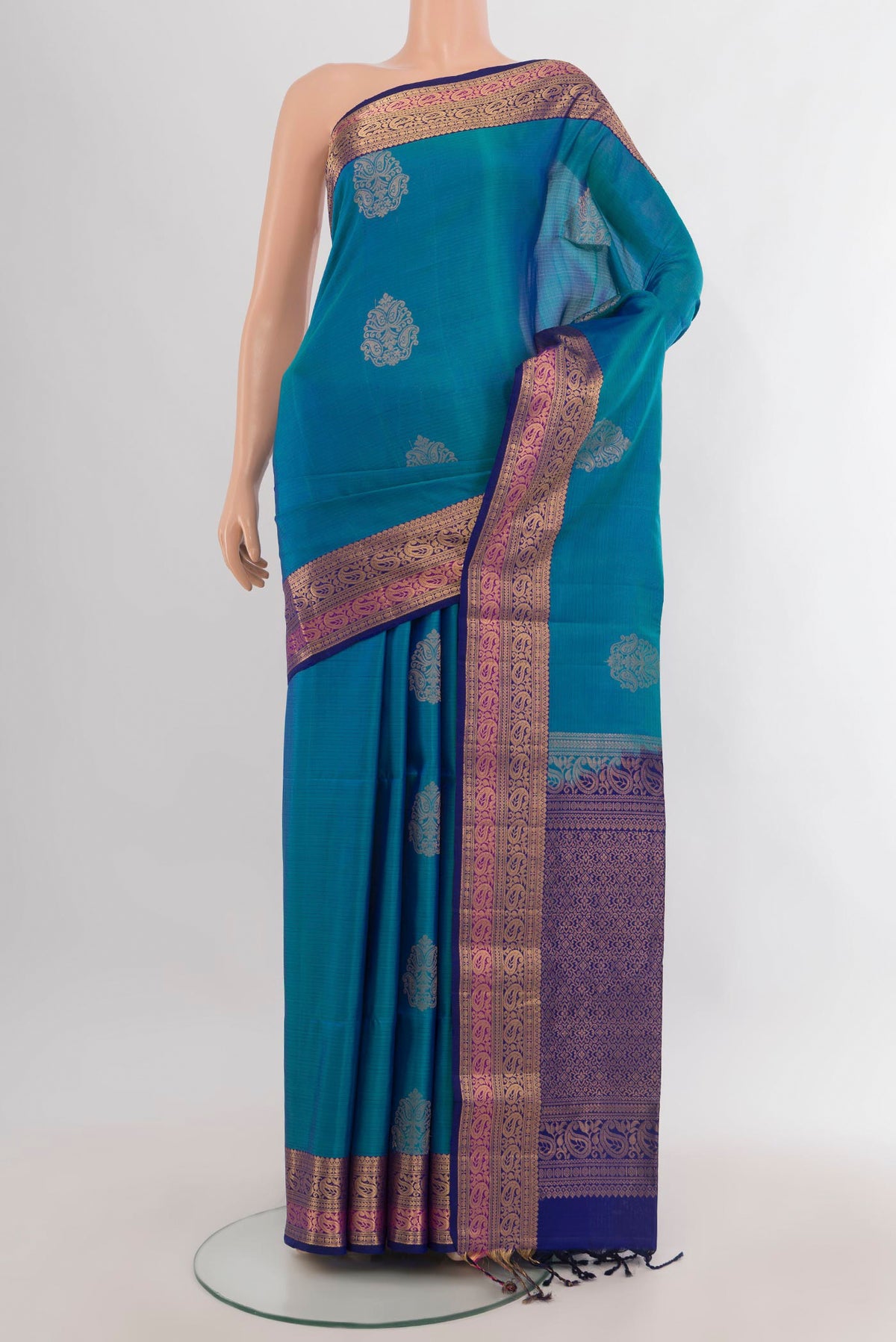 Pure Silk Peacock Blue Soft Saree with Zari Butta on the body and Zari Border.  displayed on a mannequin
